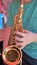 Young man plays mini saxophone with bare hands