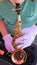 Young man plays mini saxophone while wearing white gloves