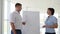 Young man pointing at flipchart gives presentation to his colleagues in office