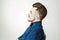 Young man with pompadour haircut, dressed in blue shirt with a serious face. side view hair for barbershop