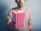 Young man with popcorn and cinema ticket