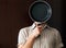 Young man portrait behind frying pan