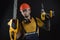 A young man posing on a black background in a work uniform and a construction tool