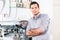 Young man posing near a modern automatic coffee machine