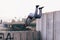 Young man practicing parkour at the city park, doing tricks and jumps