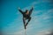 Young man practicing on the pole on blue sky background.