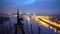 Young man practicing yoga on the edge of bridge in the evening, doing headstand