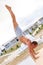 Young man practicing yoga in a urban background. Yogi handstand in pose shirshasana.