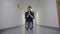 Young man prays kneeling in white corridor