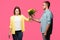 young man presenting bouquet of flowers to angry woman isolated