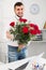 Young man is presenting flowers and gift