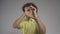 Young man pretends to be looking down a pipe in the studio. He put his finger in the rings and pretends to be watching