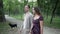 Young man and pretty woman in dress are walking in nature outdoors in Park, talk