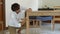 A young man professional furniture assembler assembles a wooden table in a kitchen