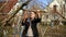 A young man is pruning trees in the garden near the house on a spring day. The concept of spring tree pruning and garden