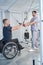 Young man pulling resistance cable in rehabilitation clinic