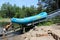 Young man pushing raft boat onto pully system after tour, Ausable Chasm, New York, 2018