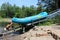 Young man pushing river boat up onto pulley after tour with guests, Ausable Chasm, New York, 2018