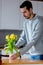 Young man put in yellow tulips in glass