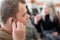 A young man puts on a hearing aid. Portable sound amplifier for the deaf and hearing impaired