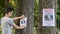 A young man puts up ads for a missing person in the park