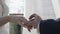 A young man puts a wedding ring on the finger of his bride.