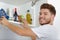 Young man putting food away in cupboard