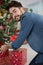 young man putting present under christmas tree