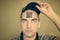 Young man with a qr code on his forehead. A man with a stupid expression looks at his qr code on his head. The concept of chipping