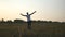 Young man with raising hands running in field and enjoying freedom. Carefree guy running on grass field at summertime