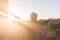 Young man raising hands up against sunlight - indicated success, achievement and victory.