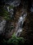 Young man rappelling abseiling from vertical rock, adventure sport at Stuiben waterfall in Reutte Tyrol Austria alps