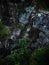 Young man rappelling abseiling from vertical rock, adventure sport at Stuiben waterfall in Reutte Tyrol Austria alps