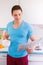 Young man reading newspaper in the kitchen portrait format morning