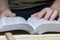 A young man reads the Bible, laying it on a wooden plank of boards.