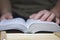 A young man reads the Bible, laying it on a wooden plank of boards.