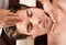 Young Man Receiving Forehead Massage In Spa