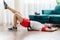 A young man in red shorts is doing exercises on a foam roller, works out of the muscles with a massage roller. Athletic