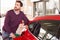 Young man refuelling a car at a petrol station