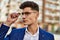 Young man relaxed wearing suit and glasses at street