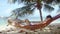 Young man relaxing in hammock on tropical beach. Man Sleeping in hammock next to the palm tree. slow motion. 1920x1080