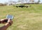 Young man with remote control cell phone flying drone. Sunny green nature