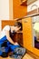 Young man repair something inside kitchen cabinet under the sink