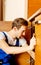 Young man repair something inside kitchen cabinet under the sink