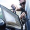 Young man repairing the broken vent glass of a car