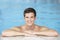 Young Man Resting On Edge Of Swimming Pool