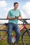 Young Man Resting On Gate And Looking At Map On Cycle Ride