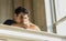 Young Man Resting with Head on Staircase Railing