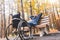 Young man resting sitting on a bench with his legs on his wheelchair.