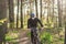 Young man ride mountain bike in forest. Young athletic man riding a bicycle in park. Male cyclist wearing face respirator, with